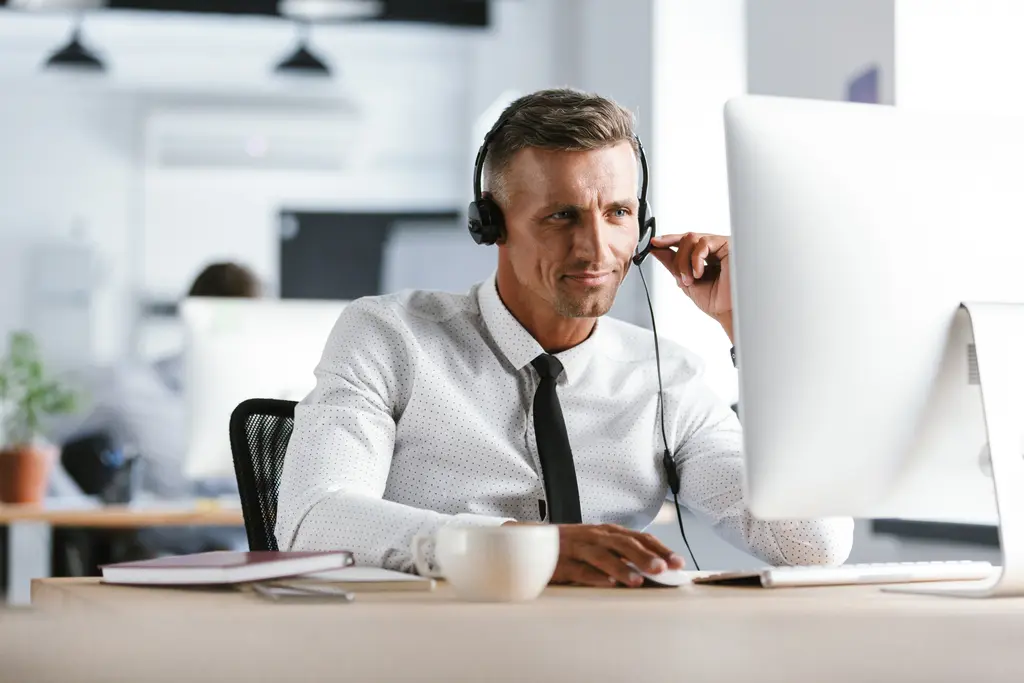 Man with a headset working at a desk