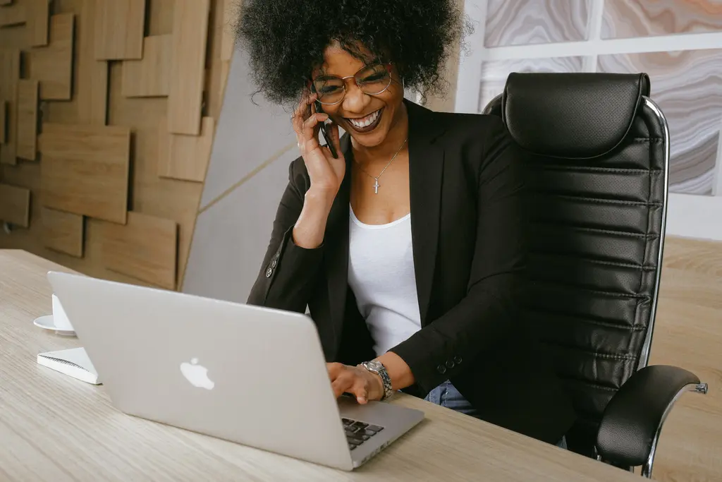 Professional taking a phone call at a desk with a laptop